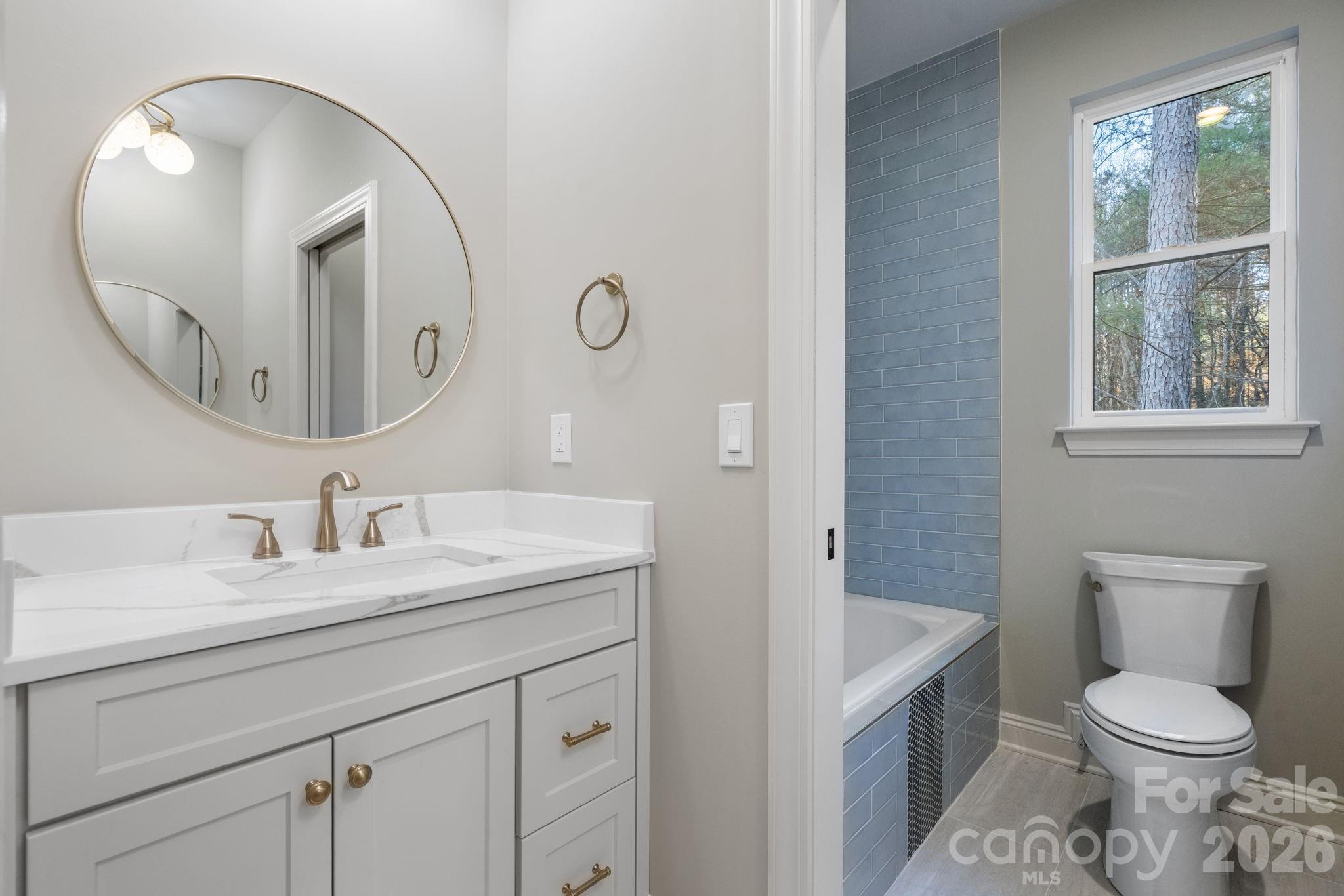 5163 Hurricane Hill Road Granite Falls, NC 28630 - Photo 26 of 40 a bathroom with a toilet a sink a mirror a vanity and window