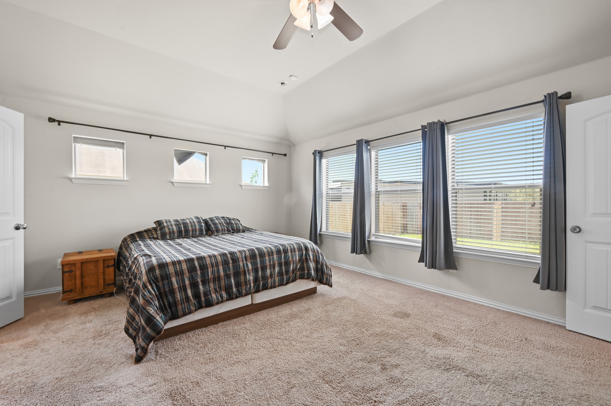 877 Hot Spring Valley Buda, TX 78610 - Photo 16 of 36 a spacious bedroom with a bed and a chandelier