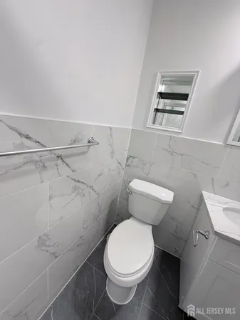 a white toilet sitting next to a bathroom sink and a shower