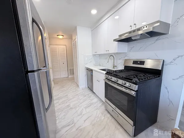 a kitchen with stainless steel appliances granite countertop a stove and a refrigerator