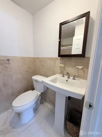 a bathroom with a toilet sink and mirror