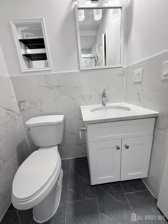 a bathroom with a toilet sink and mirror
