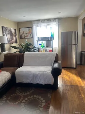 a living room with furniture and a refrigerator