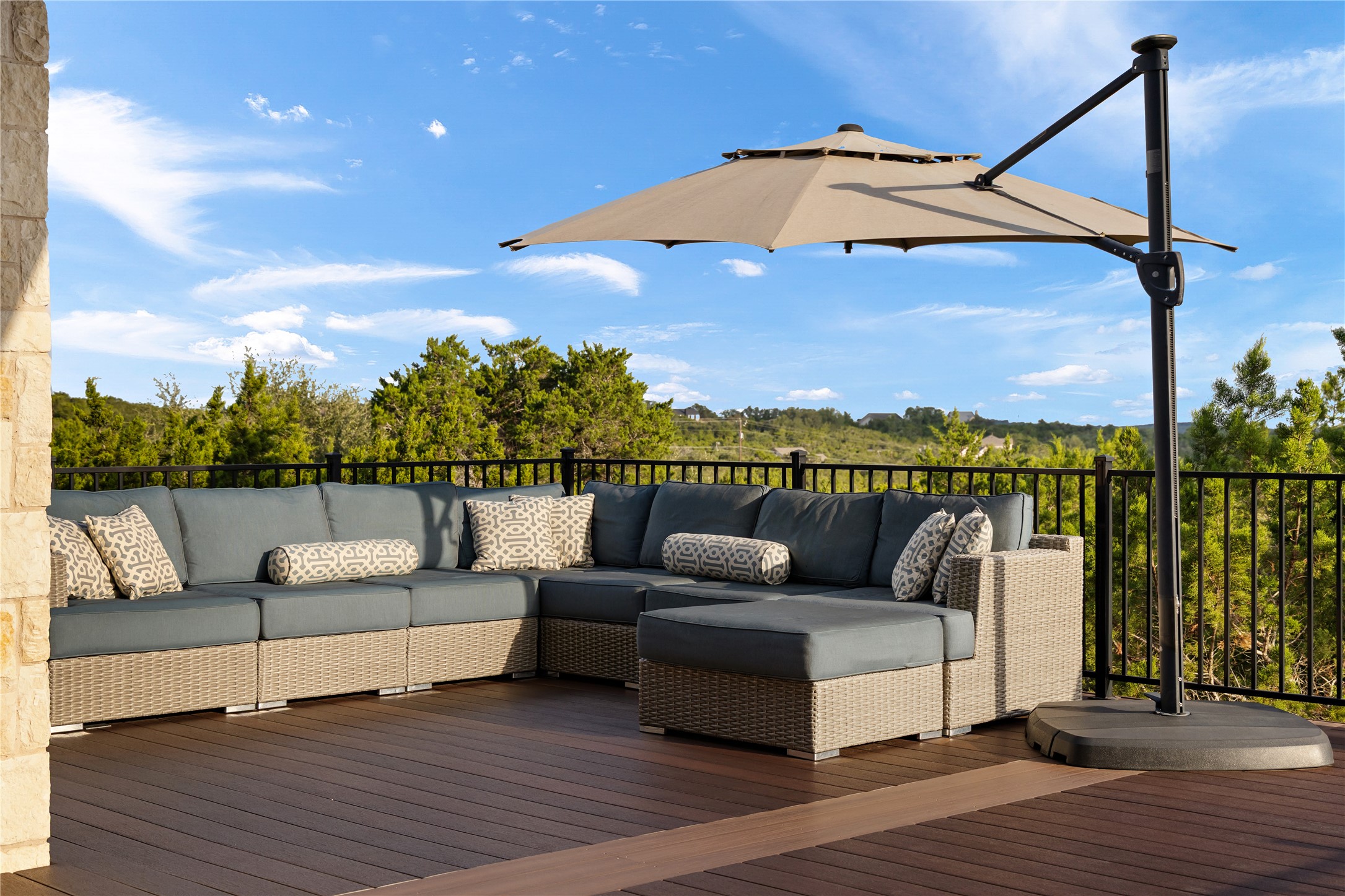 1017 Westland Ridge Road Dripping Springs, TX 78620 - Photo 30 of 40 An elevated wood deck overlooks rolling green hills under a bright blue sky.