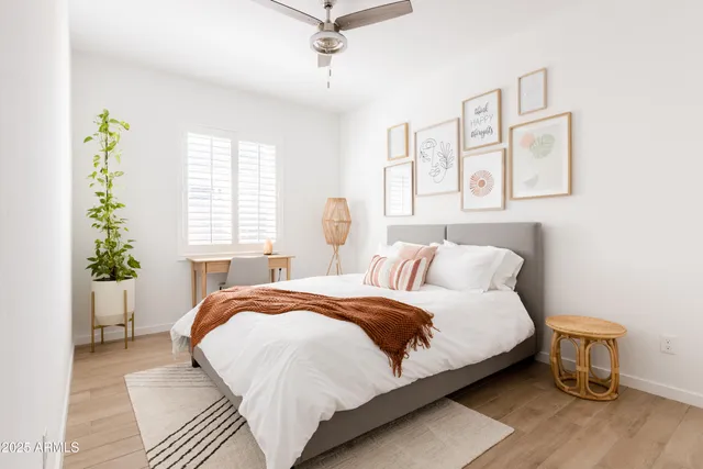a bedroom with a large bed and a potted plant