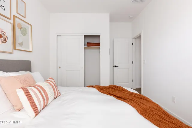 a bedroom with a bed and a painting on the wall