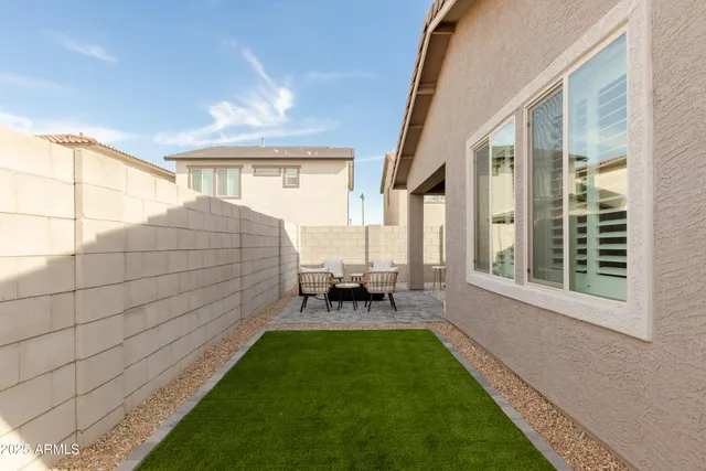 a backyard of a house with table and chairs