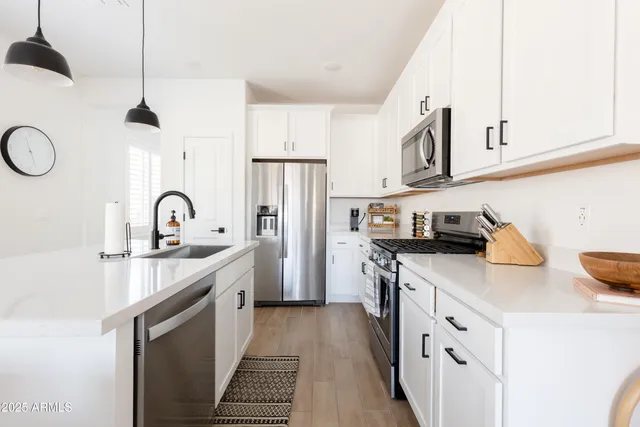 a kitchen with stainless steel appliances a sink stove and refrigerator