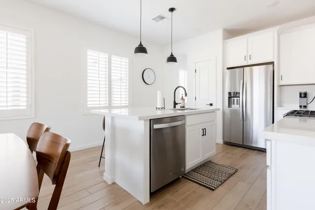 a kitchen with white cabinets and window