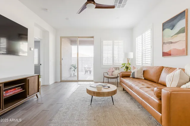 a living room with furniture a flat screen tv and a large window