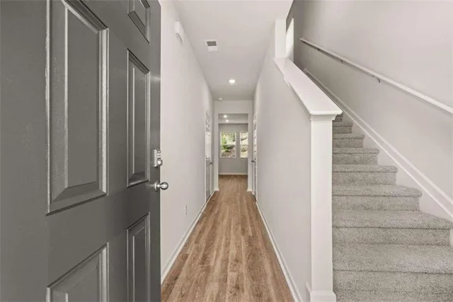 a view of a hallway with wooden floor and staircase