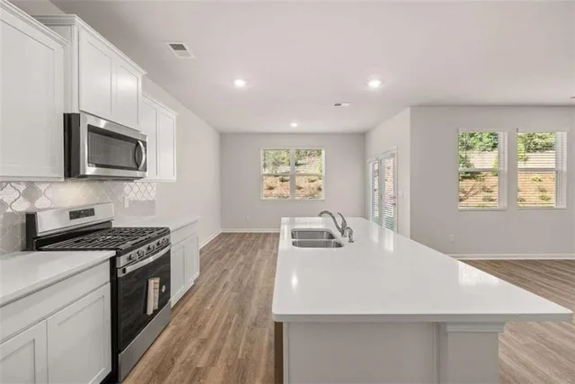 a kitchen with sink a microwave and stove