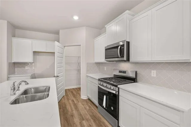 a kitchen that has a sink and a stove top oven