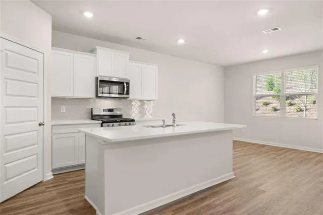 a kitchen with a sink cabinets and wooden floor