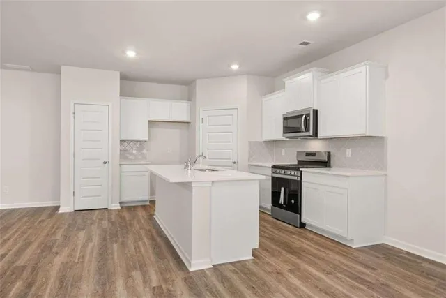 a kitchen with white cabinets stainless steel appliances and sink