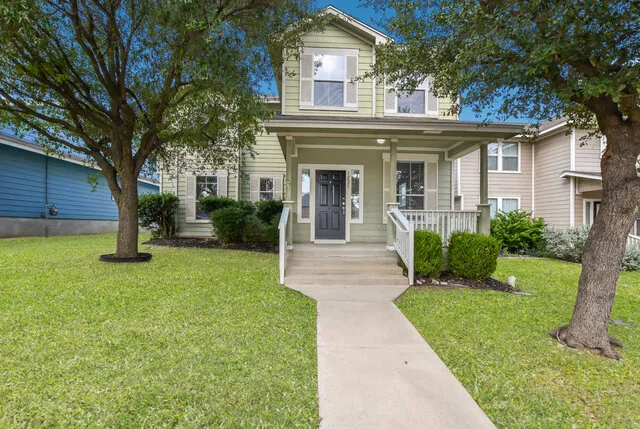 a front view of a house with a yard and trees