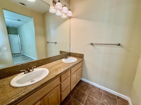 a bathroom with a granite countertop sink and a mirror