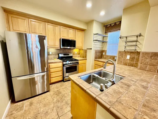 a kitchen with stainless steel appliances granite countertop a refrigerator stove and sink