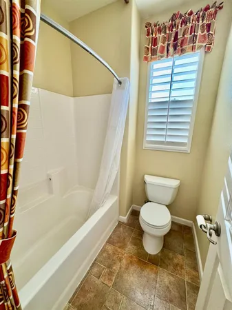 a bathroom with a toilet and a shower curtain