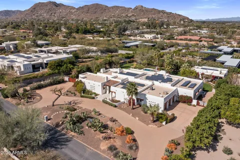 an aerial view of a house with a mountain