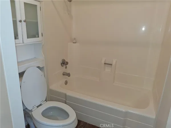 a white toilet sitting next to a bath tub