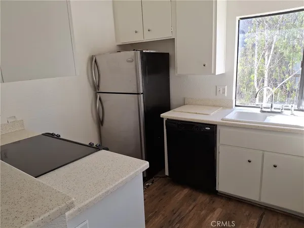 a kitchen with a sink refrigerator and window