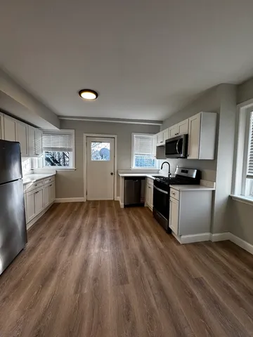 a kitchen with granite countertop a refrigerator stove top oven and sink