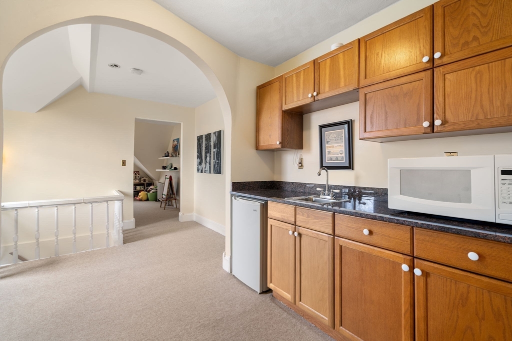 357 Crescent Street Waltham, MA 02453 - Photo 30 of 41 a kitchen with granite countertop white cabinets and stainless steel appliances