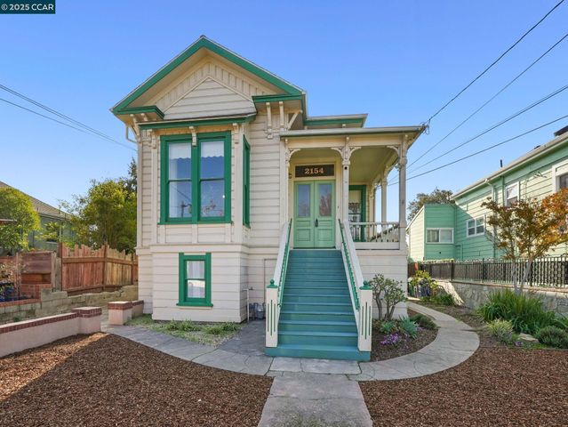 a view of a house with a small yard and wooden floor and fence