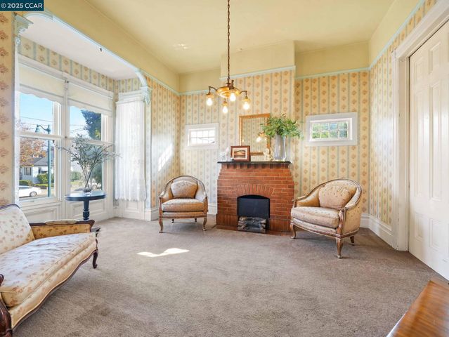 a living room with furniture a fireplace and a chandelier