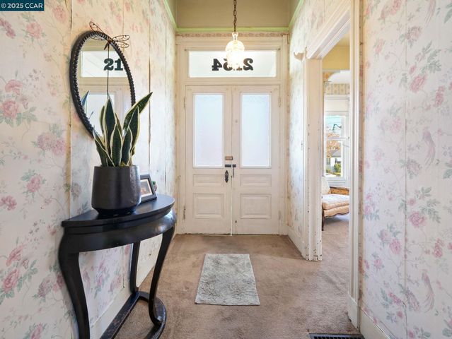 a view of a hallway with windows and chandelier