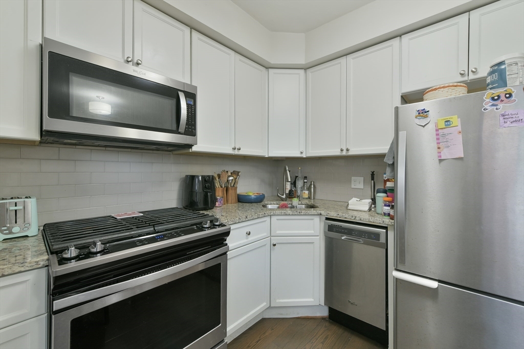 135 Havre Street, Unit 2 Boston, MA 02128 - Photo 5 of 17 a kitchen with stainless steel appliances white cabinets and a stove a refrigerator a sink