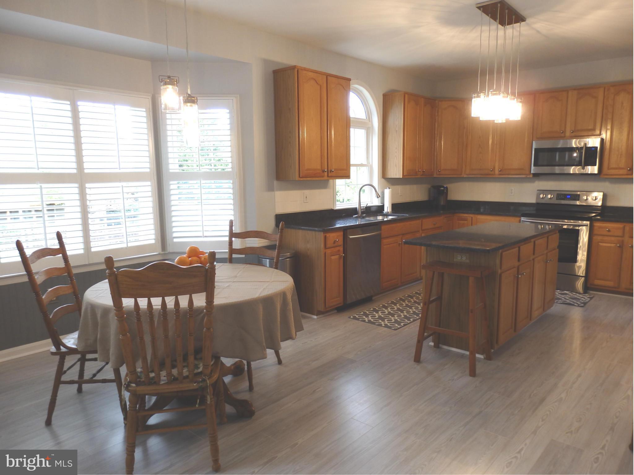 2543 Bear Den Road Frederick, MD 21701 - Photo 7 of 30 a kitchen with a dining table chairs and granite counter tops