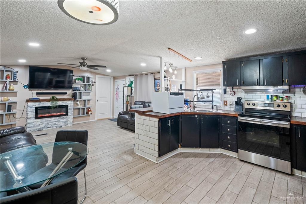 48 Gladiola Street Alamo, TX 78516 - Photo 14 of 14 a kitchen with stainless steel appliances granite countertop a stove top oven a sink dishwasher a dining table and chairs