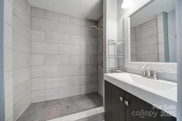 a bathroom with a sink shower and a mirror