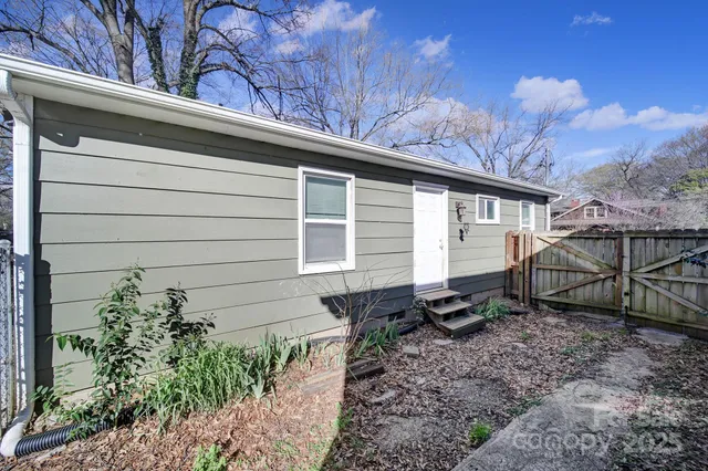 a small barn with a white roof and table and chairs