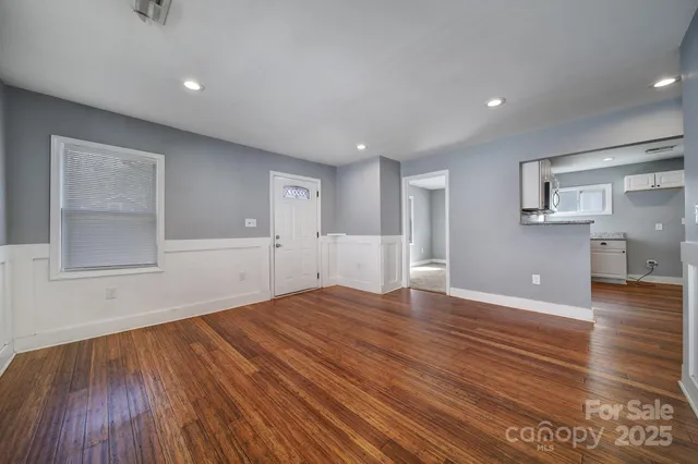 a view of empty room with wooden floor and windows