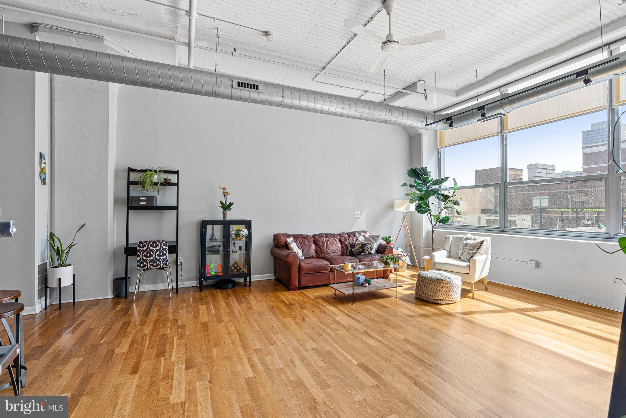 2200-28 Arch Street, Unit 409 Philadelphia, PA 19103 - Photo 6 of 25 a living room with furniture and a large window