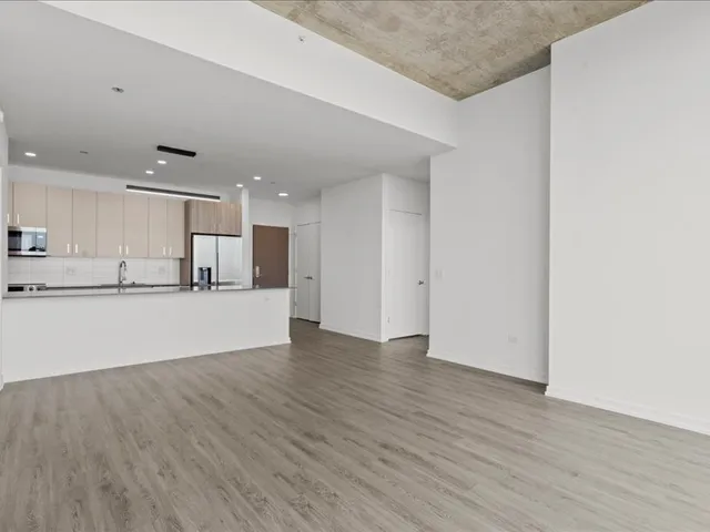 a view of kitchen with kitchen island wooden floor center island and stainless steel appliances
