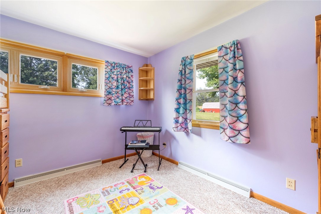 8360 Roller Road Salem, OH 44460 - Photo 21 of 45 Purple-painted room featuring light-colored carpet, two windows with wood trim, and baseboard heating