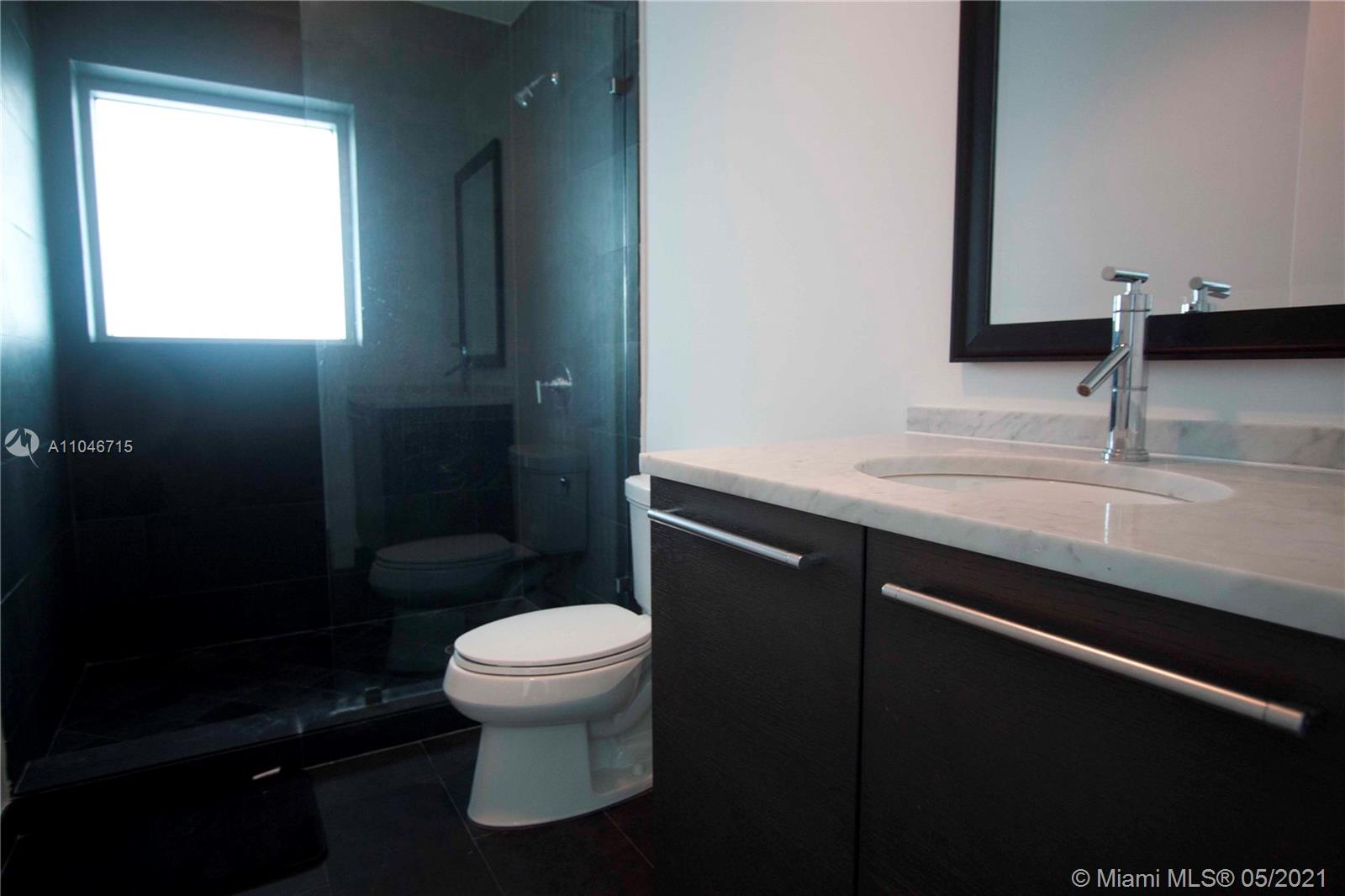 900 Biscayne Boulevard, Unit 5502 Miami, FL 33132 - Photo 12 of 19 a bathroom with a sink a toilet a mirror and shower