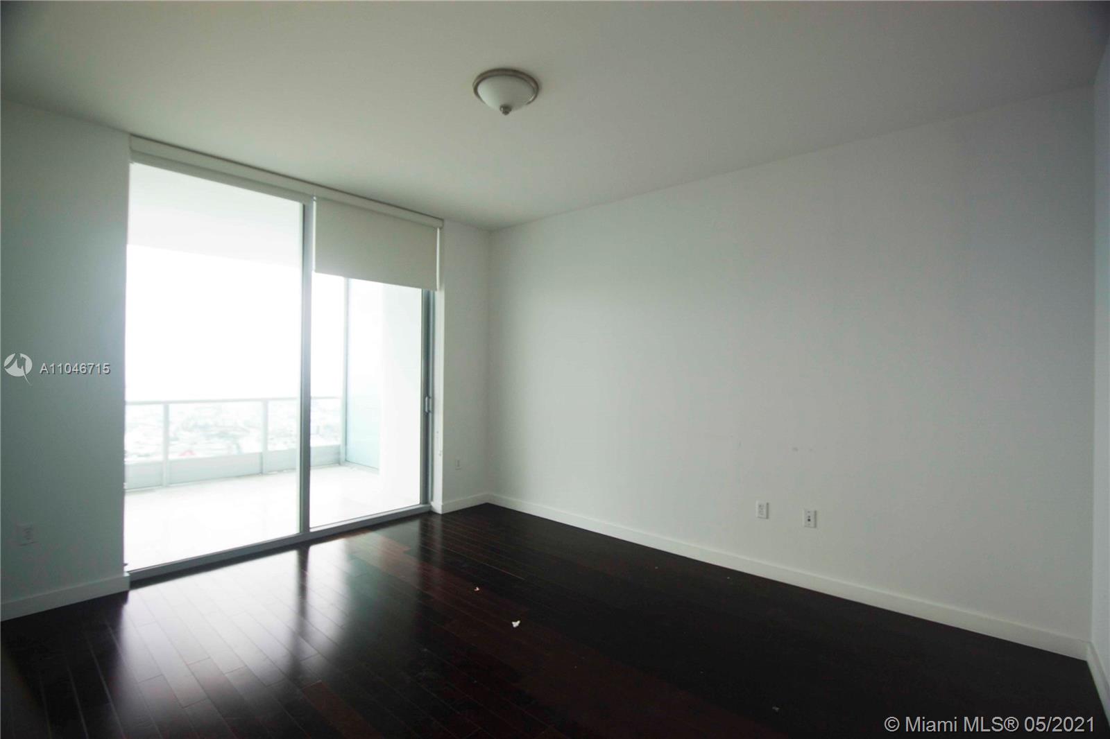 900 Biscayne Boulevard, Unit 5502 Miami, FL 33132 - Photo 10 of 19 a view of an empty room with wooden floor and a window