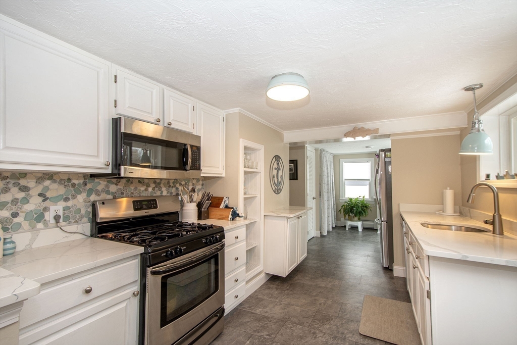 85 Constitution Road Marshfield, MA 02050 - Photo 12 of 36 a kitchen with stainless steel appliances a stove microwave and sink