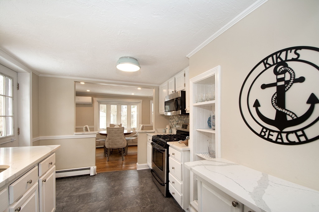 85 Constitution Road Marshfield, MA 02050 - Photo 15 of 36 a large white kitchen with a large window a sink and a stove