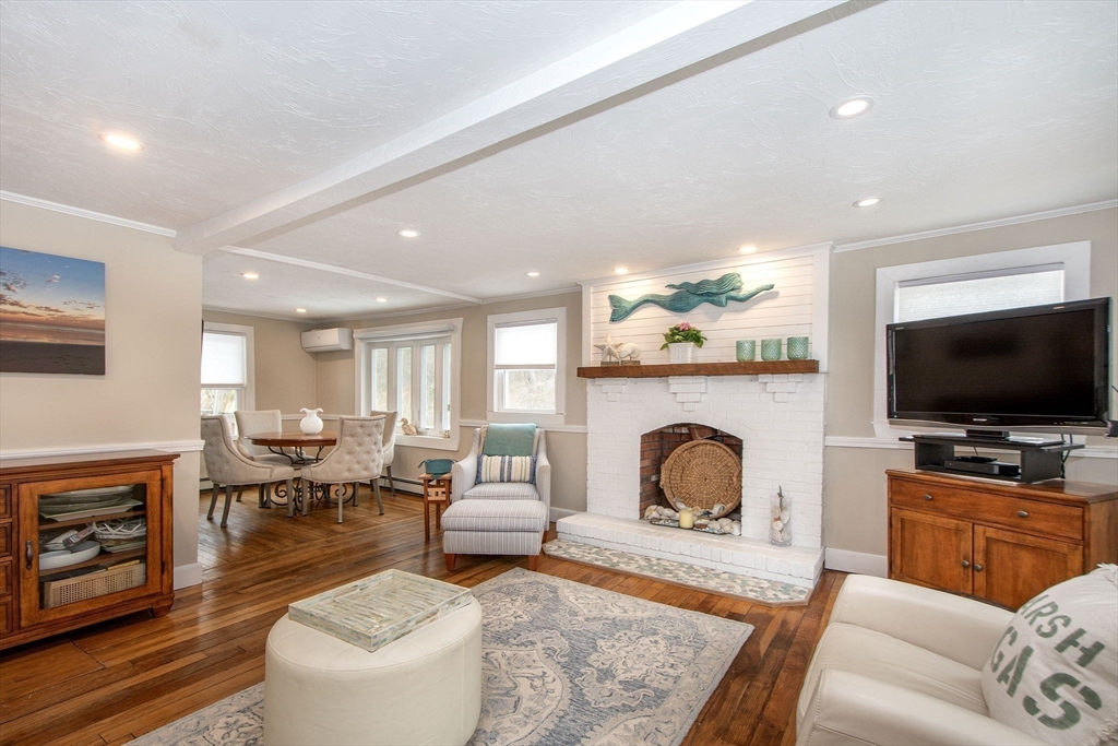85 Constitution Road Marshfield, MA 02050 - Photo 6 of 36 a living room with furniture a flat screen tv and a fireplace