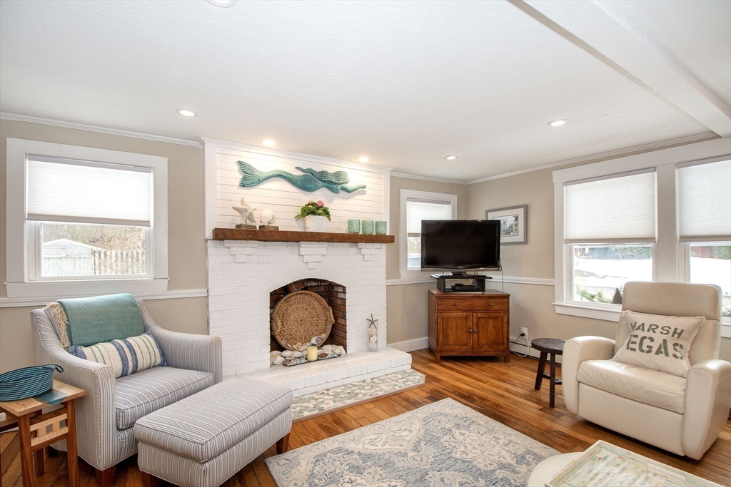 85 Constitution Road Marshfield, MA 02050 - Photo 7 of 36 a living room with furniture a flat screen tv and a fireplace