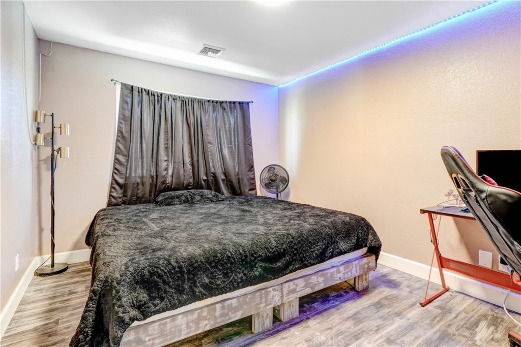 15395 Apache Road Apple Valley, CA 92307 - Photo 14 of 20 a bedroom with a bed and wooden floor