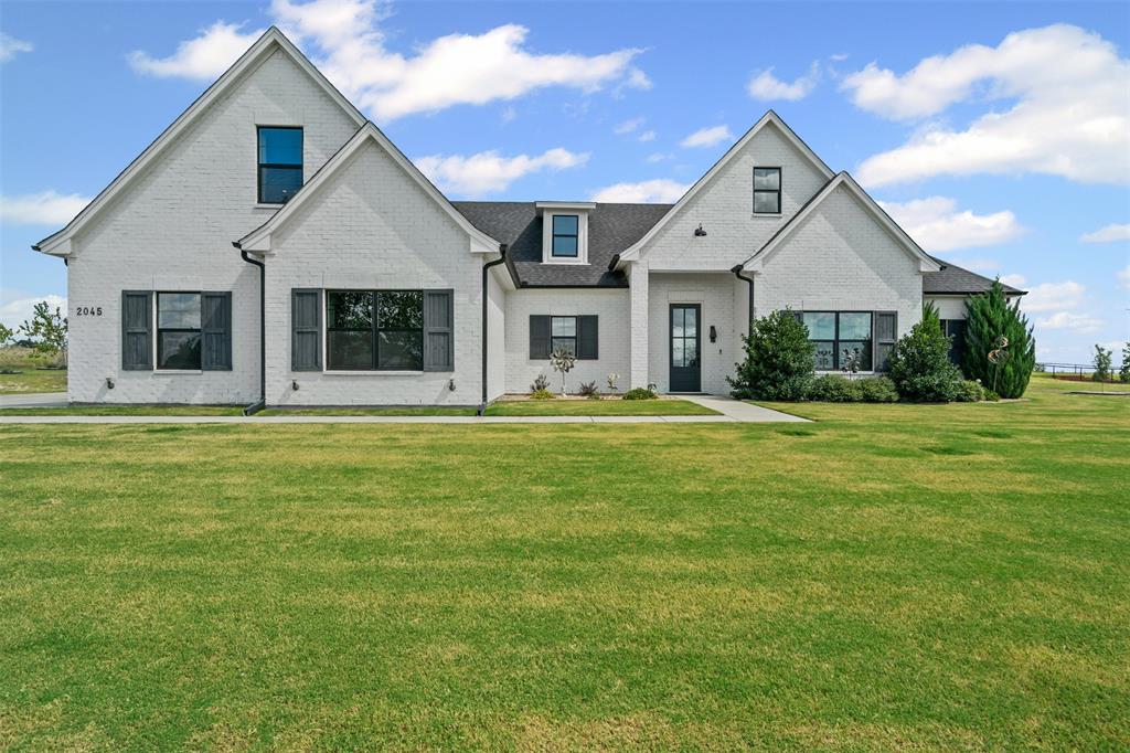 View of front of home with a front yard and brick siding