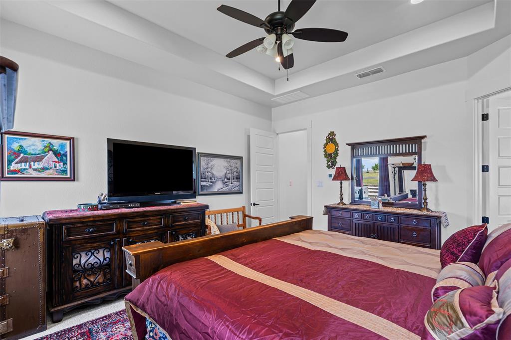 2045 Ellis Ridge Drive Weatherford, TX 76087 - Photo 15 of 40 Carpeted bedroom featuring a tray ceiling and ceiling fan