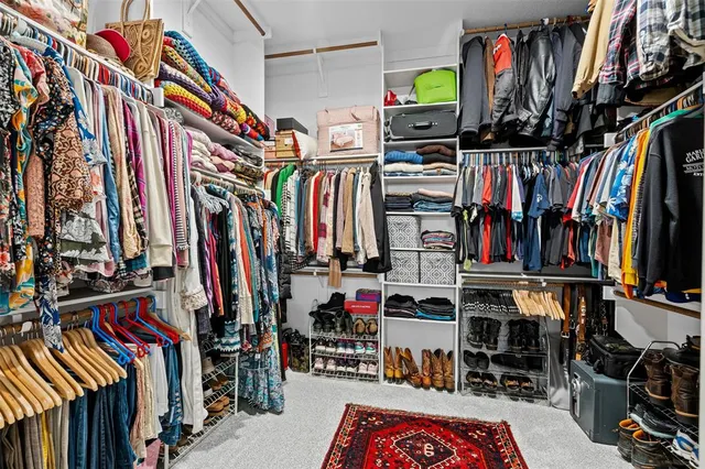 a view of walk in closet with clothes and shoes